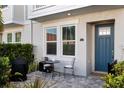 Inviting front porch with stone pavers, a blue door, and a cozy outdoor seating area at 845 Burlington N Ave, St Petersburg, FL 33701