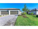 New construction home with two-car garage, beautiful landscaping, and a paver driveway at 15507 Sunny Day Dr, Bradenton, FL 34211