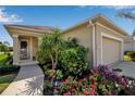 Home exterior with a well-manicured garden, flower bed, and a two-car garage at 1618 White Breeze Cv, Bradenton, FL 34208