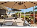 Covered outdoor patio with a seating area overlooking a serene lake view at 1618 White Breeze Cv, Bradenton, FL 34208