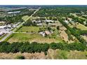 Aerial view of property featuring a verdant landscape with mature trees, a long driveway, and a residence at 16305 E State Road 64, Bradenton, FL 34212