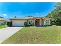 Lovely home boasting a lush green lawn and an inviting facade with a two-car garage at 1631 Madison Ave, North Port, FL 34286