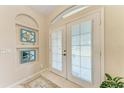 Bright foyer featuring double doors, decorative mirrors, and tile flooring, creating an inviting entrance at 1631 Madison Ave, North Port, FL 34286