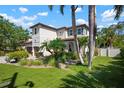 Stately two-story home with lush landscaping, including palms and manicured lawn, under a partly cloudy sky at 1719 Kenilworth St, Sarasota, FL 34231