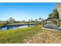 Picturesque waterfront property with a charming gazebo, lush green lawn, and stunning canal views on a sunny day at 221 Duxbury Ave, Port Charlotte, FL 33952