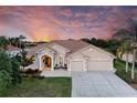 Charming beige home featuring a barrel tile roof, columns, and a manicured lawn at 251 Dove Trl, Bradenton, FL 34212