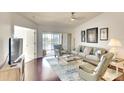 Bright living room with wood floors, comfortable seating, ceiling fan, and sliding glass doors leading to a covered patio at 2608 Waterford Way # B, Palmetto, FL 34221