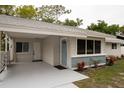 Front exterior featuring a covered carport and a freshly painted home with a decorative blue accent wall at 2722 Nancy St, Sarasota, FL 34237