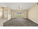 Bright living room featuring a bay window, neutral walls, plush carpet and a ceiling fan at 27255 Deep Creek Blvd, Punta Gorda, FL 33983