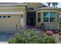 Up close image of a home featuring a two-car garage and vibrant flowers in the landscaped front yard at 3312 92Nd E Ave, Parrish, FL 34219