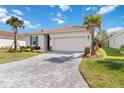 Charming single-story home with a paver driveway, neat landscaping, and barrel tile roof at 412 Daylily Blvd, Nokomis, FL 34275