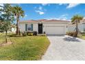 Charming one-story home with a two-car garage, well-manicured lawn, and lush tropical landscaping at 412 Daylily Blvd, Nokomis, FL 34275