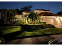 Elegant home with meticulously manicured landscaping and a charming tile roof at twilight at 4668 Tuscana Dr, Sarasota, FL 34241