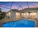 Private backyard pool with screened-in lanai, brick pavers and a beautiful view of the home's exterior at 4715 Spinnaker Dr, Bradenton, FL 34208