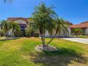 Inviting front yard with lush green lawn and mature palm trees at 4729 Peridia E Blvd, Bradenton, FL 34203
