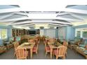 Inviting community meeting room with tables, chairs, bookshelves, and a large TV at 4835 Gulf Of Mexico Dr # 106, Longboat Key, FL 34228