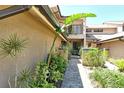 Inviting pathway leading to the townhome entrance, surrounded by vibrant tropical foliage at 5230 Landings Blvd # 101, Sarasota, FL 34231