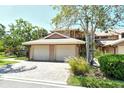 Townhome featuring a two-car garage and brick paver driveway at 5230 Landings Blvd # 101, Sarasota, FL 34231