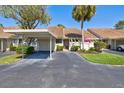 Inviting villa with a carport, lush landscaping, and a well-manicured lawn at 5354 Myrtle Wood # 50, Sarasota, FL 34235
