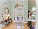 Bright foyer with stylish chandelier, decorative table, and transom window above the door at 5616 90Th Avenue E Cir, Parrish, FL 34219