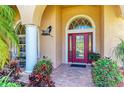 Inviting front entrance with decorative glass door, pillar, and colorful landscaping at 5616 90Th Avenue E Cir, Parrish, FL 34219