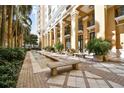 Inviting courtyard with fountains, benches, manicured greenery, and colonnade in a relaxing outdoor space at 750 N Tamiami Trl # 1203, Sarasota, FL 34236
