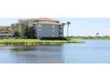 Beautiful view of the water with grassy landscaping and condo building at 7803 Grand Estuary Trl # 205, Bradenton, FL 34212