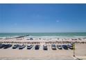 Expansive beach view showcasing ocean, pier, parking, and beach goers on a clear day at 901 Gulf S Dr # 3, Bradenton Beach, FL 34217