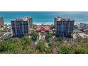 Beautiful exterior of a beachfront property with lush greenery and manicured landscaping at 1241 Gulf Of Mexico Dr # 603, Longboat Key, FL 34228