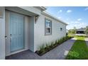 Inviting home exterior showcasing a blue front door, stylish trim, and neatly planted garden at 16114 Ivy Ridge Ct, Port Charlotte, FL 33953