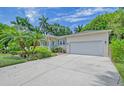 Beige exterior view showcasing a large garage door and well-maintained landscaping at 1960 Lincoln Dr, Sarasota, FL 34236