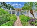 Inviting home with a brick pathway leading to a covered front porch and blue door at 1960 Lincoln Dr, Sarasota, FL 34236