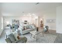 Open-concept living room with neutral decor, a tiled floor, and a view of the adjacent dining area and kitchen at 21061 Delake Ave, Port Charlotte, FL 33954