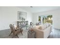 Bright living room with sliding glass doors to the yard and modern, neutral décor at 21061 Delake Ave, Port Charlotte, FL 33954