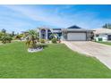 Single-story home with a well-maintained lawn and an attached two-car garage at 23088 Allen Ave, Port Charlotte, FL 33980