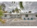 Charming single-story home featuring a white exterior, lovely landscaping and a paved driveway at 306 Island Cir, Sarasota, FL 34242