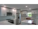 Modern kitchen features white cabinets, stainless steel appliances, and an island with quartz countertop at 306 Island Cir, Sarasota, FL 34242
