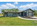 Charming single-story home with a well-maintained lawn, palm trees, and an inviting walkway leading to the front door at 3260 Pinetree St, Port Charlotte, FL 33952