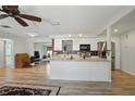 Open kitchen featuring a large island, modern appliances, white cabinets, and wood-look flooring at 3260 Pinetree St, Port Charlotte, FL 33952