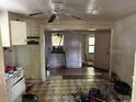 Open kitchen area shows dated cabinetry, worn flooring, and connected rooms at 3619 18Th E St, Bradenton, FL 34208