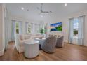Bright living room featuring stylish furniture, ample natural light, and a mounted flatscreen TV at 408 Magnolia Ave, Anna Maria, FL 34216