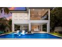 Beautiful backyard showcasing a private pool with lounge chairs and an outdoor living area at 408 Magnolia Ave, Anna Maria, FL 34216