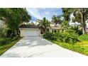 Charming home with attached garage, lush landscaping, and mature trees, creating a warm and inviting curb appeal at 4326 Brackenwood Ct, Sarasota, FL 34232