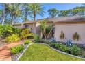 Well-maintained front yard displays tropical landscaping, including palm trees and agave plants, with a brick walkway at 4947 Greencroft Rd # 175, Sarasota, FL 34235