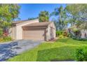 Exterior view of the home showing the attached garage, driveway, and landscaped front yard at 4947 Greencroft Rd # 175, Sarasota, FL 34235