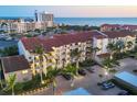 Beautiful condo building with palm trees, exterior staircases, covered parking, and brick paved parking lot at 6236 Midnight Pass Rd # 300, Sarasota, FL 34242