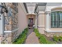 Inviting front entrance with stone accents, a decorated front door, and manicured landscaping at 7044 Whittlebury Trl, Bradenton, FL 34202
