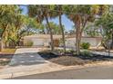 Charming home with a red front door, palm trees, a well-maintained lawn, and a spacious driveway at 717 Treasure Boat Way, Sarasota, FL 34242
