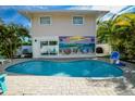 Inviting pool and patio area with colorful Anna Maria mural, perfect for outdoor relaxation at 811 Jacaranda Rd, Anna Maria, FL 34216