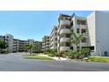 Condo building with manicured landscaping showing circular stairways and covered parking on a sunny day at 835 S Osprey Ave # 310, Sarasota, FL 34236